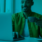 freelancer working on his laptop in the coffee shop while drinking coffee