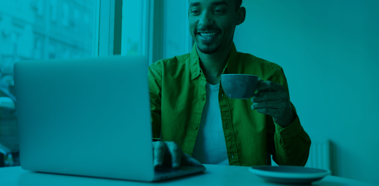 freelancer working on his laptop in the coffee shop while drinking coffee